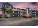 Condo exterior with private balconies, palm trees, and ample parking under a vibrant sky at 4503 W Harbour Ct. # S-6, Little River, SC 29566