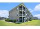 Large condo building features multiple balconies, lush landscaping, and exterior lighting fixtures at 4503 W Harbour Ct. # S-6, Little River, SC 29566
