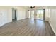 Living room featuring sliding doors to balconies, wood-look flooring, and a hallway at 5000 Windsor Green Way # 204, Myrtle Beach, SC 29579