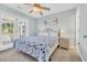 Well lit bedroom featuring a queen bed, soft carpet, a ceiling fan and bright window at 512B S Ocean Blvd., Surfside Beach, SC 29575