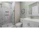 Modern bathroom boasts a stylish glass shower, a marble-tiled shower with built-in shelving, and vanity with a framed mirror at 55 Porch Ln., Pawleys Island, SC 29585
