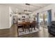 Well-lit dining area features wood floors, modern light fixture, and a view to the kitchen and outdoor space at 55 Porch Ln., Pawleys Island, SC 29585