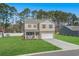 Charming two-story home with a brick-accented facade, manicured lawn, and a two-car garage at 55 Porch Ln., Pawleys Island, SC 29585