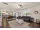 Open-concept living room with wood floors, a ceiling fan, and a view of the kitchen and dining area at 55 Porch Ln., Pawleys Island, SC 29585