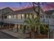 Charming elevated home with inviting front porch and covered parking, set against a colorful sunset sky at 6001 - 8008 S Kings Hwy., Myrtle Beach, SC 29575