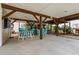Large covered outdoor area with dining table, bar seating, TV, swing and lush landscaping for relaxation and entertainment at 6001 - 8008 S Kings Hwy., Myrtle Beach, SC 29575