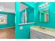 Bright teal bathroom with a white vanity and view into the connected bedroom and exterior window at 614 Cavandish Dr., Myrtle Beach, SC 29588