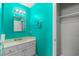 Bright teal bathroom featuring a white vanity with chrome fixtures and a mirrored medicine cabinet at 614 Cavandish Dr., Myrtle Beach, SC 29588