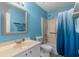 Blue bathroom featuring a shower/tub combo with blue curtain and a white sink and toilet at 614 Cavandish Dr., Myrtle Beach, SC 29588
