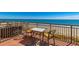 Balcony overlooking ocean with table, chairs, and metal railings at 6900 N Ocean Blvd. # 513, Myrtle Beach, SC 29572