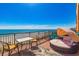 Balcony view of the beach and ocean with a lounging area and table set at 6900 N Ocean Blvd. # 513, Myrtle Beach, SC 29572