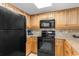 Well-equipped kitchen with black appliances, light wood cabinets, and durable countertops at 7100 N Ocean Blvd. # 221, Myrtle Beach, SC 29572