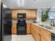 Functional kitchen with black appliances, wooden cabinets, and a sink with views at 7100 N Ocean Blvd. # 221, Myrtle Beach, SC 29572