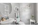 Cozy half bathroom with pedestal sink, round mirror, and tasteful decorations at 712 Painted Bunting Dr. # B, Murrells Inlet, SC 29576