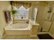 Bathroom featuring a soaking tub under a window and a separate glass enclosed shower at 7471 Balmore Dr. Sw, Sunset Beach, NC 28468