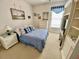 Bedroom featuring blue bedspread, dresser, and window with lots of natural light at 7471 Balmore Dr. Sw, Sunset Beach, NC 28468