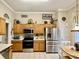 Well-lit kitchen with stainless steel appliances, oak cabinets, and tiled flooring at 7471 Balmore Dr. Sw, Sunset Beach, NC 28468