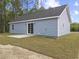 Back exterior view featuring light blue siding and a sliding glass door leading to a concrete patio at 813 Highway 67, Loris, SC 29569