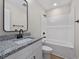 Bathroom featuring a granite vanity countertop with black hardware and a tub with white enclosure at 813 Highway 67, Loris, SC 29569
