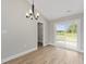 Bright dining area with a chandelier and a sliding glass door leading to the backyard at 813 Highway 67, Loris, SC 29569