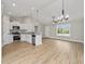 Well-lit living area with wood floors, white kitchen cabinets, and stainless steel appliances at 813 Highway 67, Loris, SC 29569