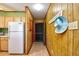 Hallway with vinyl flooring, a hat rack, wood paneling and white refrigerator at 9501 Shore Dr. # D-337, Myrtle Beach, SC 29572