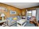Comfortable living room with couch, rattan chair, sliding glass doors to balcony and wood paneling at 9501 Shore Dr. # D-337, Myrtle Beach, SC 29572