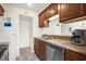 Galley kitchen features stainless dishwasher, a refrigerator, and dark wood cabinets at 9661 Shore Dr. # B-22, Myrtle Beach, SC 29572