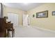 Living room with a piano, carpeted floor, neutral walls, two windows, and a closet at 1033 World Tour Blvd. # 101-A, Myrtle Beach, SC 29579