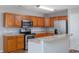 Kitchen with wooden cabinets, stainless steel appliances, breakfast bar and wood-look floors at 1108 Patricia Ct., Conway, SC 29526