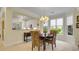 Inviting dining area with wood table, unique wicker chairs and chandelier next to the white kitchen at 12 Courtyard Circle # 36, Pawleys Island, SC 29585