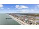 Enjoy this beautiful aerial view of beach homes near the fishing pier, located close to the ocean and marsh at 132 Garden City Retreat Dr., Murrells Inlet, SC 29576