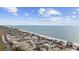 Aerial view of a coastal community with beach access, showcasing charming homes and the expansive ocean at 132 Garden City Retreat Dr., Murrells Inlet, SC 29576