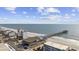 Aerial view showcases beautiful oceanfront condos and the nearby fishing pier, offering an ideal beach lifestyle at 132 Garden City Retreat Dr., Murrells Inlet, SC 29576
