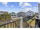Backyard view showing neighboring houses, swimming pools, and a yard enclosed by a white fence at 132 Garden City Retreat Dr., Murrells Inlet, SC 29576