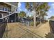 Backyard view, enclosed by a black fence, with a glimpse of a swimming pool and a neighboring house at 132 Garden City Retreat Dr., Murrells Inlet, SC 29576