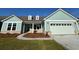 Charming single-story home with an attached two car garage, manicured lawn, and a coastal color palette at 1333 Crested Iris Way, North Myrtle Beach, SC 29582