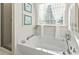 Bright bathroom featuring a garden tub with modern faucet and sheer curtains for natural light at 1412 Rainsbrook Ct., Conway, SC 29526