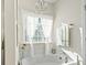 Bright bathroom featuring a garden tub with chandelier and sheer curtains for natural light at 1412 Rainsbrook Ct., Conway, SC 29526