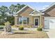 Charming brick home with a well-manicured lawn, landscaped flower beds, and inviting front entrance at 1412 Rainsbrook Ct., Conway, SC 29526