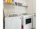 Functional laundry room with washer, dryer, and shelving for organized storage of cleaning supplies at 1412 Rainsbrook Ct., Conway, SC 29526