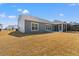 The back exterior of the home with a screened porch features a spacious yard perfect for outdoor activities and gatherings at 1414 Villena Dr., Myrtle Beach, SC 29579