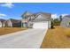 The exterior of the home features a large driveway, a two-car garage, and well-maintained landscaping for curb appeal at 1414 Villena Dr., Myrtle Beach, SC 29579