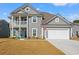 Charming two-story home with a covered porch, two-car garage, manicured lawn, and an American flag waving in the breeze at 1414 Villena Dr., Myrtle Beach, SC 29579