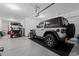 Spacious garage showcasing epoxy floors, a white jeep rubicon and golf cart, and ample storage space at 1414 Villena Dr., Myrtle Beach, SC 29579