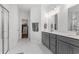 A bright main bathroom featuring double sinks, walk-in shower, and access to the walk-in closet at 1414 Villena Dr., Myrtle Beach, SC 29579