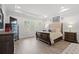 A beautiful primary bedroom featuring a tray ceiling, hardwood floors, and natural light at 1414 Villena Dr., Myrtle Beach, SC 29579