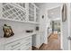 Pantry features white cabinets, quartz countertop, subway tile backsplash, and a wine rack for storage and organization at 1414 Villena Dr., Myrtle Beach, SC 29579