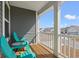 Cozy front porch features gray siding, white pillars, and two blue Adirondack chairs with a small table, perfect for relaxing at 1414 Villena Dr., Myrtle Beach, SC 29579