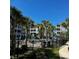 Community pool area with palm trees, lounge chairs, and surrounding condo buildings at 181 Ella Kinley Circle # 305, Myrtle Beach, NY 29588